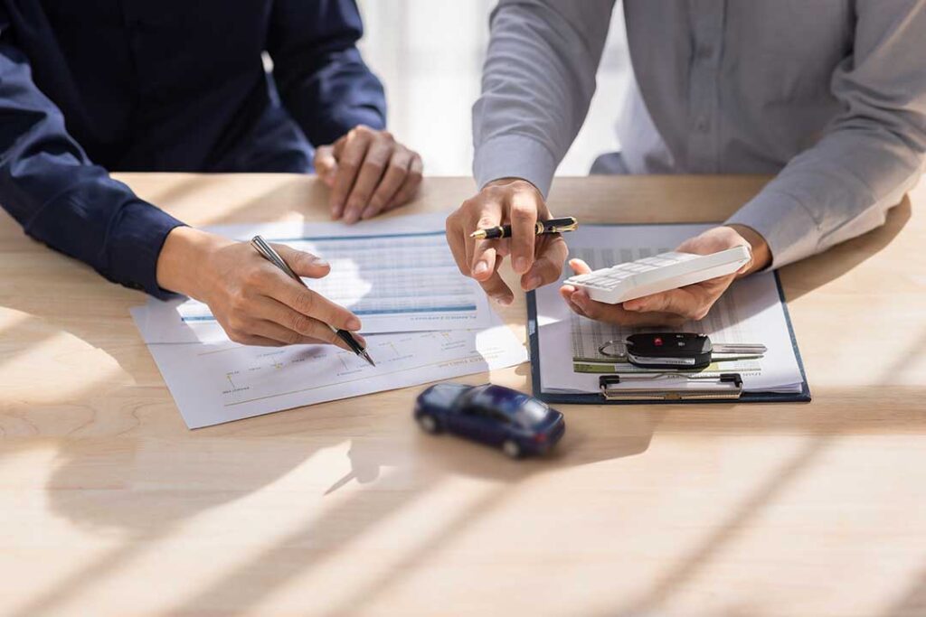 A family reviewing paperwork together at their dining table, looking focused and thoughtful.